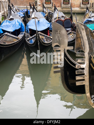 Die glänzenden sechs gezahnt "Ferro" Stücke auf der Bug einer Reihe von venezianischen Gondalas und zwei weitere Gondeln im Hintergrund Stockfoto