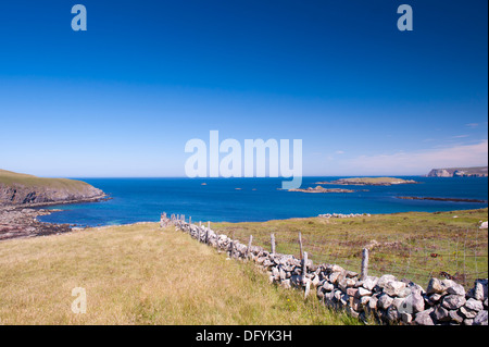 Trockenmauer, Deich, an Klippen und kleinen Insel Stockfoto