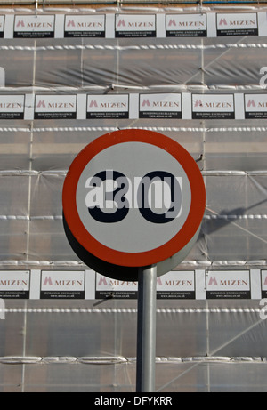 britische 30 km/h Höchstgeschwindigkeit Zeichen gesehen vor dem Hintergrund von feuerhemmenden Platten auf einer Baustelle Stockfoto