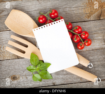 Leere Notizblatt Papier für Ihre Rezepte mit Tomaten und Basilikum auf Holztisch Stockfoto