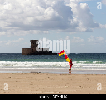 RNLI Rettungsschwimmer am Strand von St-Ouen Jersey & La Rocco tower Kanalinseln Stockfoto
