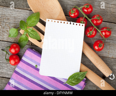 Leere Notizblatt Papier für Ihre Rezepte mit Tomaten und Basilikum auf Holztisch Stockfoto