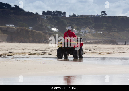 RNLI Rettungsschwimmer am Strand von St-Ouen Jersey & rot Quad Bike Channel Islands Stockfoto