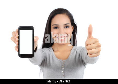 Ziemlich lächelnde Frau zeigt eine leere vertikale Smartphone-Bildschirm und Daumen isoliert auf weißem Hintergrund Stockfoto