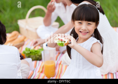 Glückliche junge Familie mit einem Picknick auf dem Rasen Stockfoto