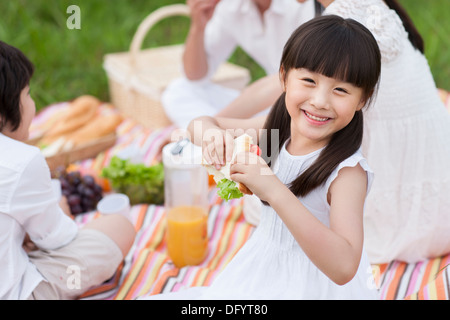 Glückliche junge Familie mit einem Picknick auf dem Rasen Stockfoto