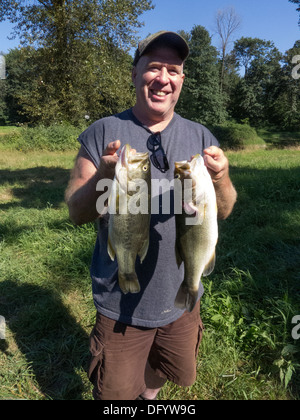 Bass Fischer zeigt großen Mund Bass, den, die er in einen Sumpf in der Nähe von Monroe, Washington gefangen. Stockfoto