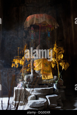 Buddha-Statue mit Golddekor und brennende Räucherstäbchen in den Ruinen des Bayon Tempel in Angkor, Kambodscha. Stockfoto