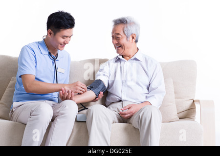 Nursing Assistent Einnahme senior woman Blutdruck Stockfoto