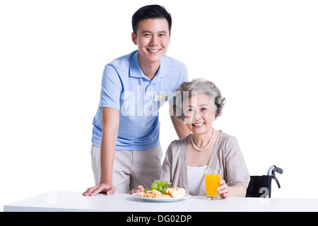 Behinderte ältere Frau mit Frühstück im Pflegeheim Stockfoto