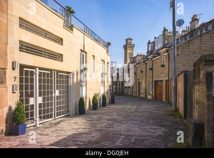 Einer kleinen gepflasterten Seitenstraße in Glasgow, alte Hütten drängeln mit der neuesten Makeover-Häuser bieten eine interessante Mischung der Straße Stockfoto