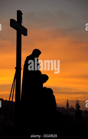 Blick auf die steinerne Skulptur Pietà auf der Karlsbrücke in Prag, Tschechische Republik, bei Sonnenuntergang am 8. Oktober 2013. Foto: Sebastian Kahnert Stockfoto