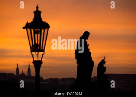 Blick auf die St. Joseph (2-R) und St. Francis Xavier (r) Steinskulpturen auf der Karlsbrücke in Prag, Tschechische Republik, bei Sonnenuntergang am 8. Oktober 2013. Foto: Sebastian Kahnert Stockfoto