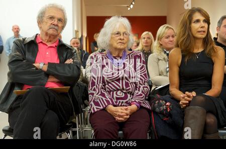 Leipzig, Deutschland. 11. Oktober 2013. Mela Ramos (L-R), seine Frau Leta und seine Tochter und Modell Rachelle Leininger stehen vor seinem Bild "The Voyeur" (1989) im Museum der Bildenden Kuenste in Leipzig, Deutschland, 11. Oktober 2013. Die Ausstellung "Beauty and the Beast - Richard Mueller & Mel Ramos & Wolfgang Joop" läuft vom 13. Oktober 2013 beziehen 12. Januar 2014. Foto: PETER ENDIG/Dpa/Alamy Live News Stockfoto