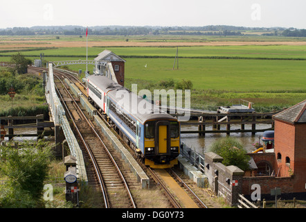 Ein paar der Klasse 153 diesel multiple units Arbeiten eine Wherry Linien service Kreuzung Reedham Drehbrücke in East Anglia. Stockfoto