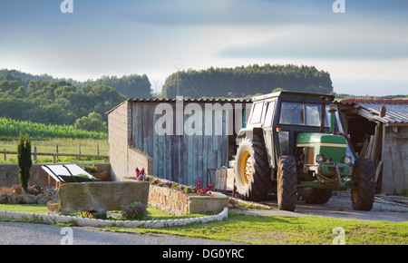 Landwirtschaftliche Zugmaschine vor eine bescheidene Holzschuppen in einer ländlichen Umgebung geparkt. Stockfoto