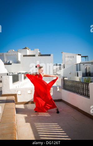 Attraktive Flamencotänzerin, die traditionellen rotes Kleid mit Blume im Haar tragen Stockfoto