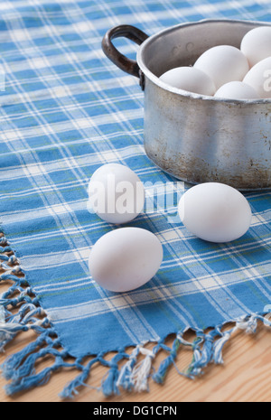 weiße Hühnereier auf blau karierter Stoff Stockfoto