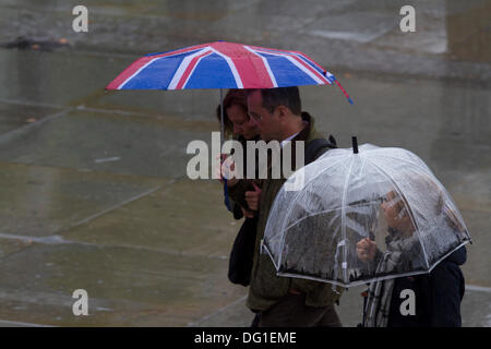 Trafalgar Square London, UK. 11. Oktober 2013.  Mitglieder der öffentlichen Tierheim unter Sonnenschirmen auf einem nassen Regentag in London Credit: Amer Ghazzal/Alamy Live-Nachrichten Stockfoto