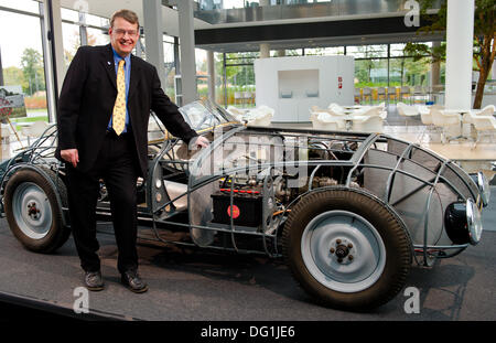 Hannover, Deutschland. 7. Oktober 2013. Der Vorsitzende der Hanomag Gemeinschaft von Interesse, Horst-Dieter Goerg steht neben eine Replik von einem Hanomag-Oldtimer in Hannover, Deutschland, 7. Oktober 2013. Die Schale ist eine aerodynamische Legierung Rennwagen mit einem 1,9-Liter-Dieselmotor, die vier Weltrekorde im Februar 1939 gewonnen. Da das Original im zweiten Weltkrieg zerstört wurde, ist es von den Mitgliedern des gemeinschaftlichen Interesse Hanomag umgebaut. Foto: Christoph Schmidt/Dpa/Alamy Live News Stockfoto