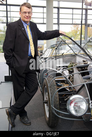 Hannover, Deutschland. 7. Oktober 2013. Der Vorsitzende der Hanomag Gemeinschaft von Interesse, Horst-Dieter Goerg steht neben eine Replik von einem Hanomag-Oldtimer in Hannover, Deutschland, 7. Oktober 2013. Die Schale ist eine aerodynamische Legierung Rennwagen mit einem 1,9-Liter-Dieselmotor, die vier Weltrekorde im Februar 1939 gewonnen. Da das Original im zweiten Weltkrieg zerstört wurde, ist es von den Mitgliedern des gemeinschaftlichen Interesse Hanomag umgebaut. Foto: Christoph Schmidt/Dpa/Alamy Live News Stockfoto