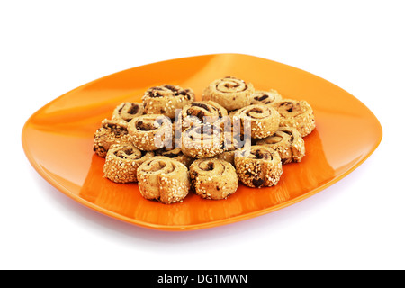 Zwieback mit Sesam und Oliven auf orange Teller isoliert auf weißem Hintergrund. Stockfoto