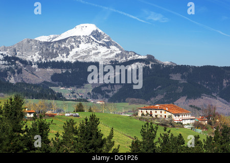 Dorf im Aramaio Tal, umgeben von schneebedeckten Bergen, im Baskenland Stockfoto