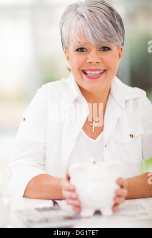 fröhliche senior Frau Holding Sparschwein Stockfoto