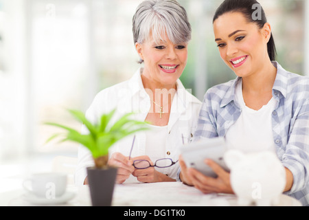 glückliche Tochter helfen mittlere betagte Mutter, die ihren Ruhestand Investitionen berechnen Stockfoto