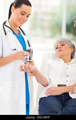 freundliche Krankenschwester Prüfung Mitte im Alter des Patienten Puls Stockfoto