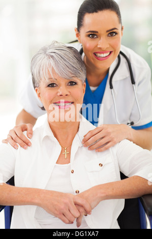 Porträt von glücklich senior Frau im Rollstuhl mit Betreuer Stockfoto