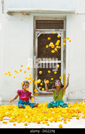 Indische Bauerndorf Mädchen spielen Ringelblumen in der Luft zu werfen. Andhra Pradesh, Indien Stockfoto