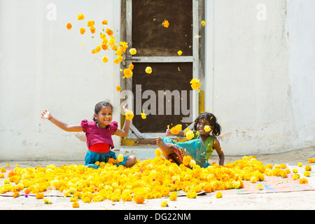 Indische Bauerndorf Mädchen spielen Ringelblumen in der Luft zu werfen. Andhra Pradesh, Indien Stockfoto