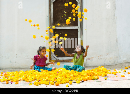 Indische Bauerndorf Mädchen spielen Ringelblumen in der Luft zu werfen. Andhra Pradesh, Indien Stockfoto