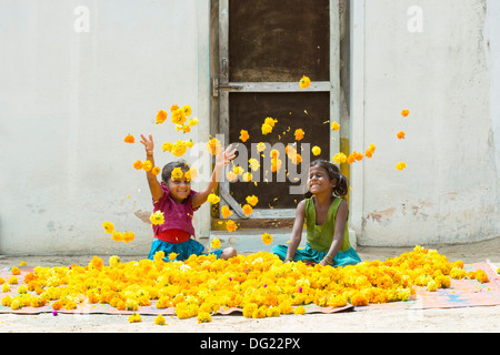 Indische Bauerndorf Mädchen spielen Ringelblumen in der Luft zu werfen. Andhra Pradesh, Indien Stockfoto