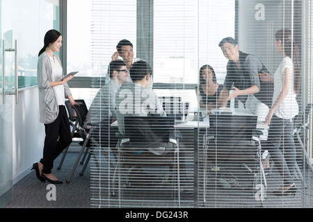 Junge Büroangestellte, die Einberufung einer Sitzung Stockfoto
