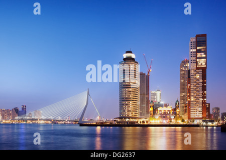 Stadt Rotterdam Innenstadt Skyline in der Abenddämmerung in Süd-Holland, Niederlande, Erasmus-Brücke auf der linken Seite. Stockfoto