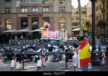 Barcelona, Spanien-12. Okt. 2013.A Spielzeug Ente in den Straßen von Barcelona mit einem Mann mit einer spanischen Flagge. Hispanic Tag (spanischen Nationalfeiertag) zeichnet sich durch die Krise stalking Spanien und die wachsende Nachfrage nach Unabhängigkeit von der katalanischen Bevölkerung. Einige tausend Menschen demonstrierten für die Vereinigung der spanischen Territorium. Bildnachweis: Jordi Boixareu/Alamy Live-Nachrichten Stockfoto