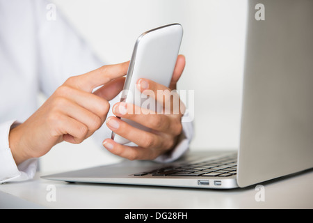 Weibliche Laptop Handy-Finger Tisch Schreibtisch indoor Stockfoto