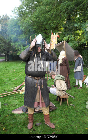 - Battle Sussex UK 12 Oktober 2013 - Mitglieder von Die Regia Anglorum Gesellschaft an ihrem sächsischen Lager beteiligt In der Schlacht von Hastings 1066 Wochenende in Battle Abbey In East Sussex heute -Mitglieder der Regia Anglorum Society Sächsische Kettenpost-Kampfkleid für historische Nachstellung anziehen Stockfoto