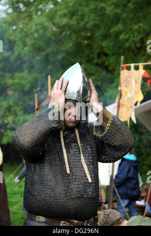 - Battle Sussex UK 12 Oktober 2013 - Mitglieder von Die Regia Anglorum Gesellschaft an ihrem sächsischen Lager beteiligt In der Schlacht von Hastings 1066 Wochenende in Battle Abbey In East Sussex heute -Mitglieder der Regia Anglorum Society Sächsische Kettenpost-Kampfkleid für historische Nachstellung anziehen Stockfoto