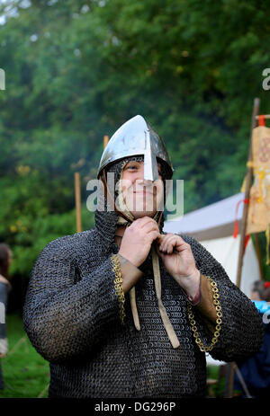 - Battle Sussex UK 12 Oktober 2013 - Mitglieder von Die Regia Anglorum Gesellschaft an ihrem sächsischen Lager beteiligt In der Schlacht von Hastings 1066 Wochenende in Battle Abbey In East Sussex heute -Mitglieder der Regia Anglorum Society Sächsische Kettenpost-Kampfkleid für historische Nachstellung anziehen Stockfoto