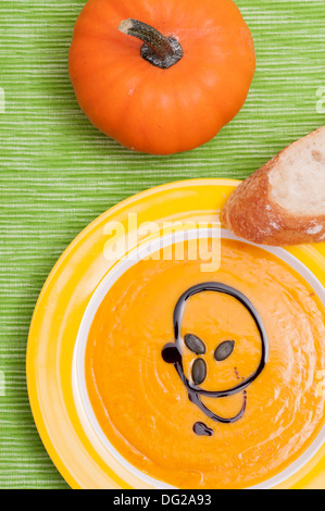 Kürbis Cremesuppe mit Brot auf einem grünen Tuch Stockfoto
