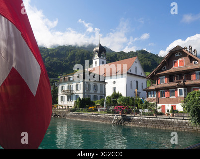 Schifffahrt auf dem Vierwaldstättersee Schweiz, Beckenried, verlassen, Kirche und Schweizer Flagge am Heck Stockfoto