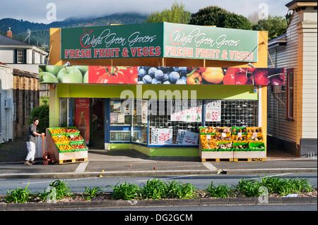 Waihi, North Island, Neuseeland. Lebensmittelhändler öffnet seinen Store in den frühen Morgenstunden und verschüttete Flüssigkeiten Obst auf dem Bürgersteig in der kleinen Goldgräberstadt. Stockfoto