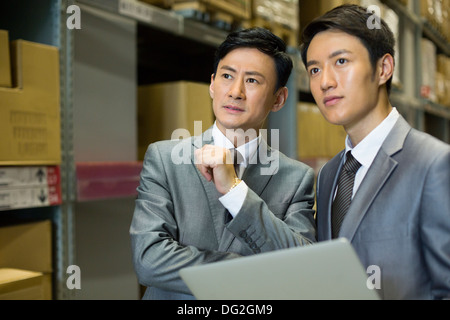 Geschäftspartner mit Laptop im Logistikzentrum Stockfoto