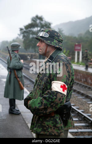 1940 Kriegszeit Armee Mann an Levisham. North Yorkshire, UK. 11. Oktober, 2013. Deutsche Station wachen oder feldgendarmerie an die "Eisenbahn in Kriegszeiten "North Yorks Moors Railway (NYMR) Fall an Levisham Bahnhof in schlechtem Wetter am Wochenende 12. und 13. Oktober 2013. Levisham, war mit Postern dekoriert, und Französisch während der Kriegszeit (NYMR) 'Wochenende'' Le Visham zu werden' im Norden Frankreichs. Die Sammlung, die Erholung von einem französischen Dorf, das von deutschen Truppen besetzt, die Teil der "Allo Allo" - style unbeschwerte und lustige Stimmung. Stockfoto