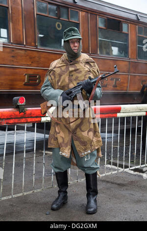 1940 Militärmann der Kriegsarmee in Levisham. North Yorkshire, Großbritannien. Oktober 2013. Bob Fleming, ein deutscher Soldat, der die Eisenbahn mit einem MG 34-Maschinengewehr bei der Veranstaltung ‘Railway in Wartime’ North Yorks Moors Railway (NYMR) am 2013. Oktober im Bahnhof Levisham bewacht. Levisham Station, wurde während des (NYMR) ‘Kriegswochenendes’ mit antiken Plakaten und französischen Schildern geschmückt, um ‘Le Visham’ in Nordfrankreich zu werden. Die Versammlung, eine Nachbildung eines französischen Dorfes, das vom Zweiten Weltkrieg, dem Zweiten Weltkrieg, dem Zweiten Weltkrieg, dem Zweiten Weltkrieg, WW2 deutschen Truppen, Stockfoto