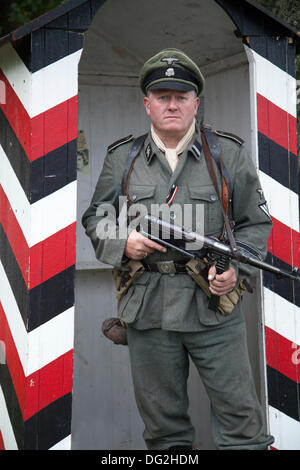 1940 Mann der Kriegsarmee in Levisham. North Yorkshire, Großbritannien. 11.. Oktober 2013. Rottenführer Deutscher Soldat ‘Nazi-Partei paramilitärischer Rang in Wachkasten bei der Militärveranstaltung der North Yorks Moors Railway im Bahnhof Levisham am 2013. Oktober. Der Bahnhof Levisham wurde während des (NYMR) ‘Kriegswochenendes’ mit antiken Plakaten und französischen Schildern geschmückt, um in Nordfrankreich ‘Le Visham’ zu werden. Das Treffen ist eine Nachbildung eines französischen Dorfes, das vom Zweiten Weltkrieg, dem Zweiten Weltkrieg, dem Zweiten Weltkrieg, dem Zweiten Weltkrieg und WW2 deutschen Truppen besetzt wurde. Stockfoto