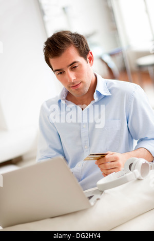 Männliche Laptop Kreditkarte Musik indoor Stockfoto